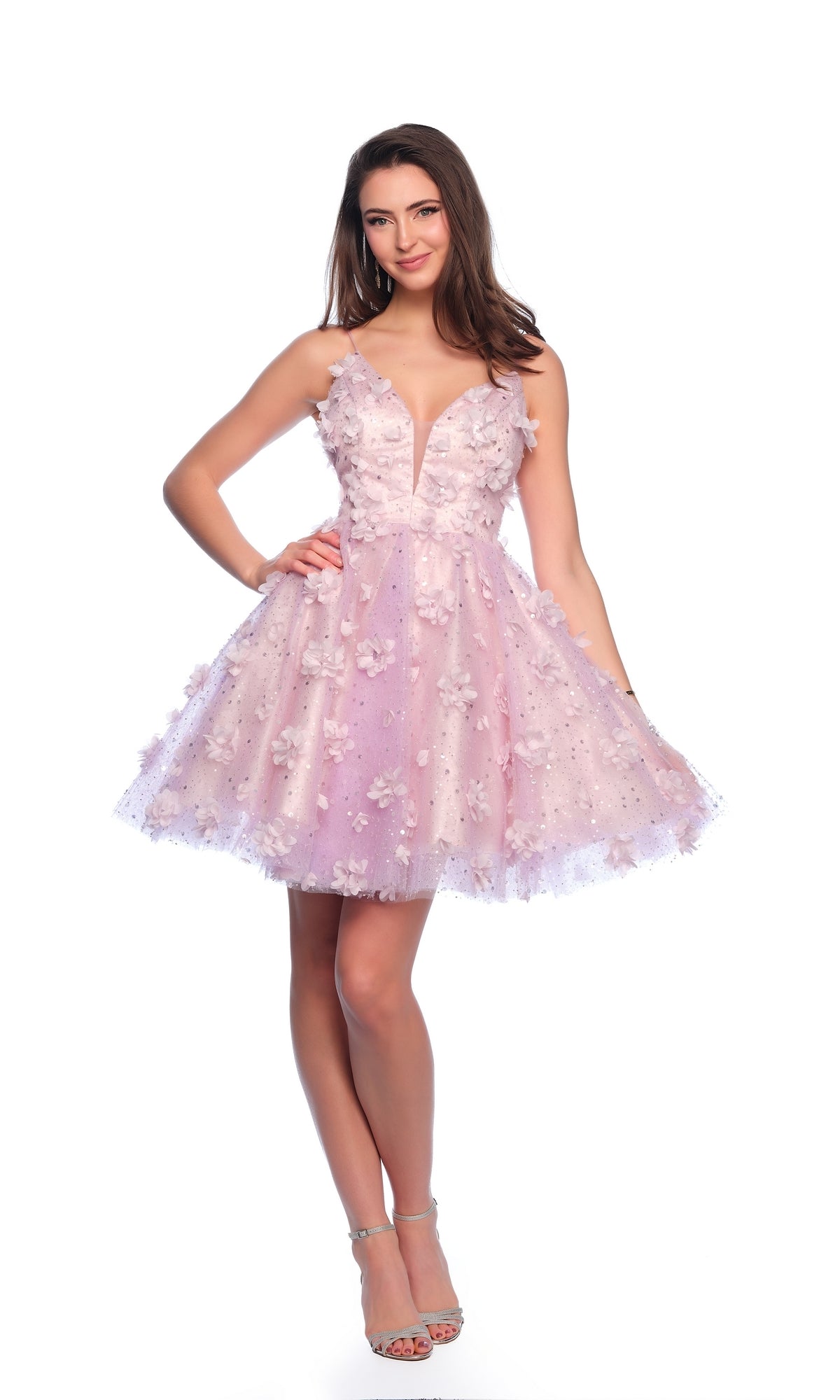 A woman stands smiling against a white background, wearing the Dave and Johnny Short Purple Hoco Dress 11751—a short, sleeveless purple designer dress—paired with silver high-heeled sandals.